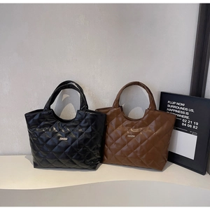 Gros plan de sacs cabas matelassés en cuir PU noir et marron avec logo métallique