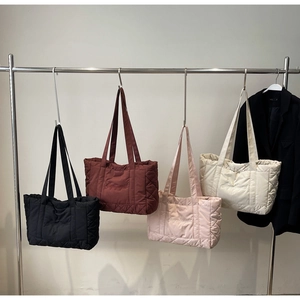 Quilted tote bags in four colors featuring diamond stitching and elegant embroidery details