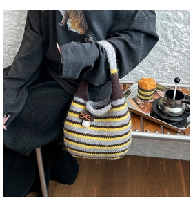 Close-up of retro striped knit handbag with mushroom charm in a cozy afternoon tea scene