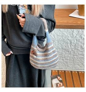 Detail of striped knit tote bag with plush texture and cute mushroom charm accessory