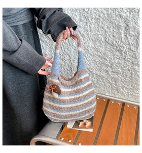 Detail of striped knit tote bag with 3D mushroom accent on a wooden bench