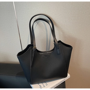 Detail shot of black lychee grain leather tote bag with metal zipper and fashion logo