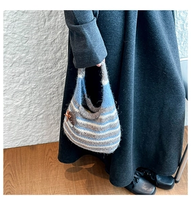 Detail of hand-knitted striped tote bag with brown mushroom pendant and bow accent