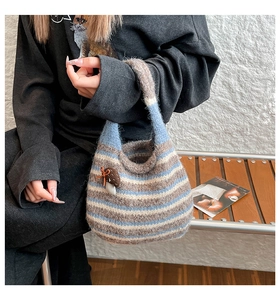 Detail of knit striped bucket bag featuring a 3D brown mushroom ornament decoration