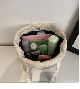 Top view showing large interior capacity of the quilted nylon tote bag with daily items