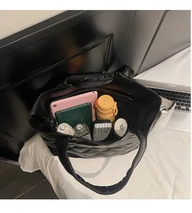 Intérieur spacieux du cabas matelassé noir montrant la capacité pour tablette et objets