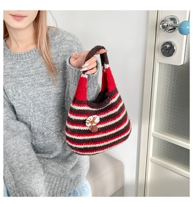 Close-up of a striped knit handbag with a cute 3D mushroom patch and soft texture