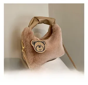 Détail du sac en peluche avec poignée en cuir nouée et joli pendentif en ours