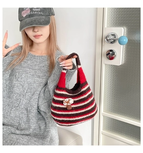 Detail of knitted striped tote bag featuring a cute 3D mushroom ornament and soft texture
