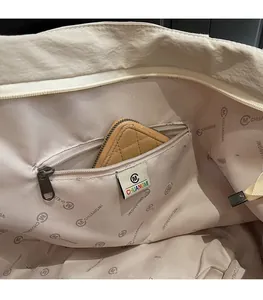 Detail view of large tote bag interior showing logo lining and internal zipper pocket