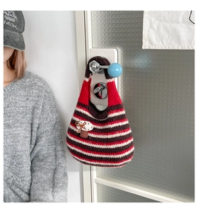 Close-up of striped knit tote bag featuring a 3D mushroom patch on white door handle