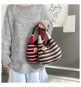 Close-up of striped knit tote bag with 3D mushroom charm and bow detail in soft wool