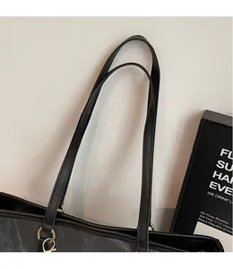 Detail of durable black nylon tote bag featuring slim synthetic leather shoulder straps