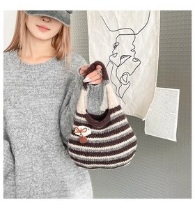 Close-up of striped knit bucket bag featuring a cute mushroom patch and soft texture