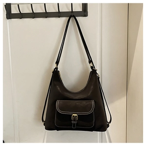 Detail of hobo bag featuring contrast stitching, gold buckle, and front pocket design