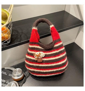 Detailed close-up of knit tote bag featuring red stripes and cute 3D mushroom accent
