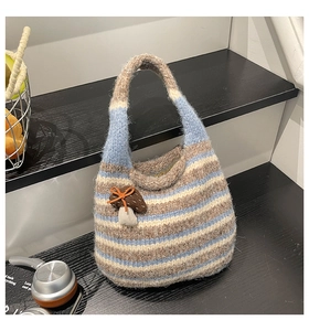 Detail of hand-knitted striped bucket bag featuring cute 3D mushroom charm accessory