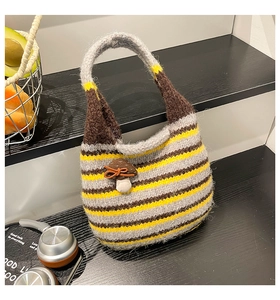 Detailed knit texture of a colorful striped bucket bag with a cute mushroom pendant