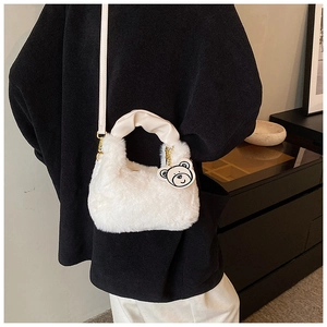 Détail d'un sac à main blanc en peluche avec pendentif ours et poignée en cuir