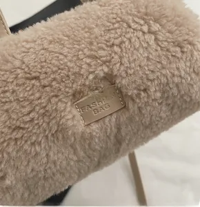 Detailaufnahme von Plüsch-Lammwollstoff und Lederpatch mit Prägung auf beigefarbener Tasche