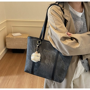 Detail of grey marble texture tote bag with fluffy charm and fashion-trend print