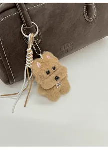 Charm chien en peluche avec étiquette TOP DOG sur un sac à main en cuir marron