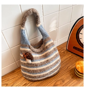 Close-up of a striped woven bucket bag with mohair texture and mushroom charm