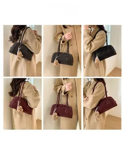 Détail de sacs fourre-tout vintage noirs et bordeaux avec charme d'ours en peluche