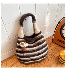 Detail of striped knit bucket bag featuring a 3D mushroom accent and textured weave