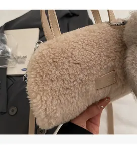 Detail der beigen Plüschtasche mit weicher Textur, Ledergriff und Metallringen im Fokus