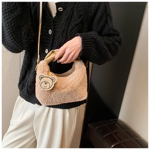 Dettaglio della borsa beige in ecopelliccia con ciondolo a forma di orso e tracolla