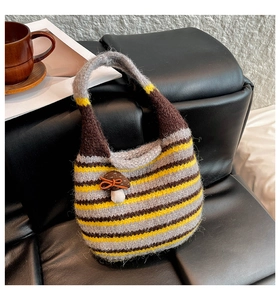 Close-up of striped knitted bucket bag with a cute mushroom pendant on a sofa