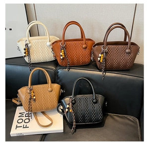 Detail view of woven leather handbags in beige, orange, brown, and black with beads