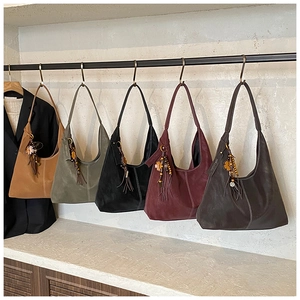 Detail view of large matte tote bags with side tassels and flower charms in five colors