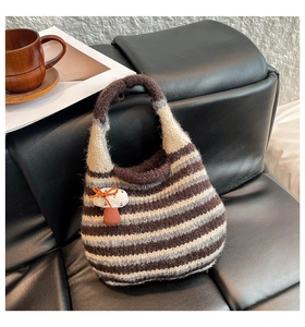 Close-up of knit tote bag with horizontal stripes and cute mushroom pendant charm