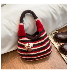 Detail of knitted bucket bag with striped pattern and cute mushroom patch decoration
