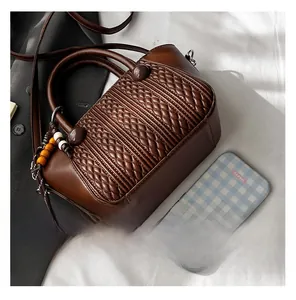 Detailed view of dark brown woven texture handbag with wooden bead pendant and strap