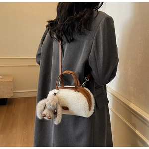 Detailansicht der weißen Plüschtasche mit Lederbesatz und süßem Kaninchen-Anhänger