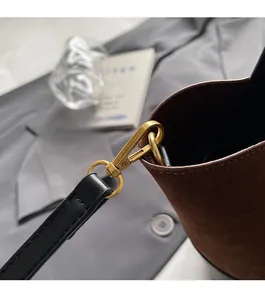 Close-up of premium suede bucket bag with gold-tone hardware and vintage color blocking