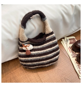 Detail of hand-knitted striped tote bag featuring a cute mushroom patch and bow