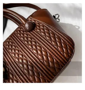 Close-up of premium brown faux leather handbag showing detailed diamond stitching and texture