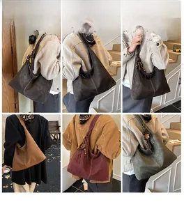 Détail du sac Hobo vintage avec perles en bois, pompons et texture en daim lisse
