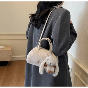 Detail der Plüsch-Handtasche mit Lederriemen und niedlichem Hasen-Anhänger-Accessoire