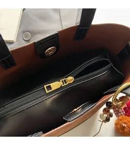 Detail of premium bucket bag with gold zipper closure and colorful tassel charm