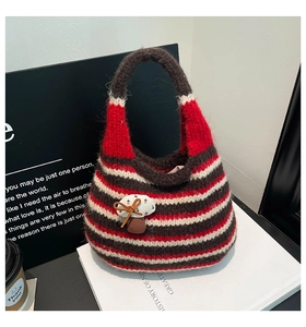 Detailed knit texture of a handmade striped bucket bag with a cute mushroom bow patch