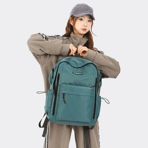 Peacock blue waterproof nylon backpack shown on model for size and capacity detail