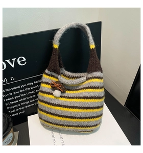 Detail of a knit striped bucket bag with a mushroom charm and textured weave