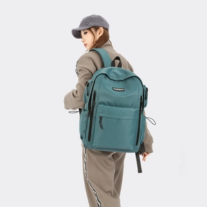 Detail view of water green nylon backpack featuring functional zip pockets and drawstring side pouch
