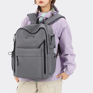 Side view of gray high-capacity travel backpack featuring multiple zip pockets and logo
