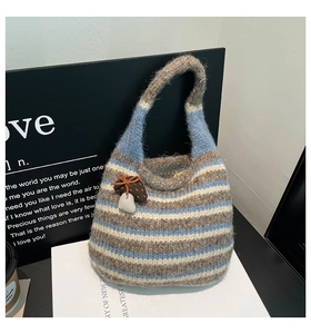 Detail of colorful striped knit bucket bag featuring a soft mohair texture and mushroom charm